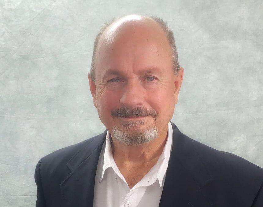 A man with a beard and mustache wearing a suit.